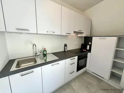 a white kitchen with a sink and a refrigerator at Le studio des Guillemins - Boverie, Gare in Liège