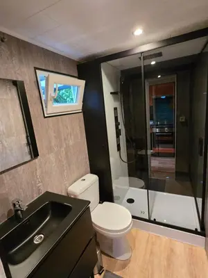 a bathroom with a toilet and a sink and a shower at Tiny Lodge met prive Jacuzzi in Lanaken
