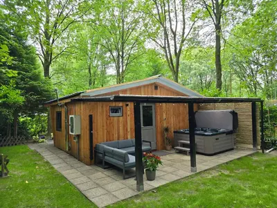 a large shed with a hot tub and a grill at Tiny Lodge met prive Jacuzzi in Lanaken