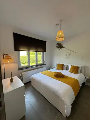 a bedroom with a large bed and a window at Comme chez vous in Soumagne