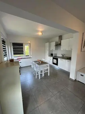 a kitchen with a table and chairs in a room at Comme chez vous in Soumagne
