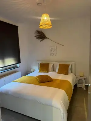 a bedroom with a large white bed with a yellow blanket at Comme chez vous in Soumagne