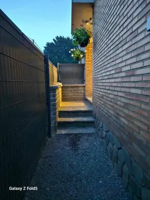 a brick wall with a stairway leading to a house at Comme chez vous in Soumagne