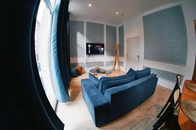 a living room with a blue couch and a table at Urbanchic Adalbert 1A in Liège