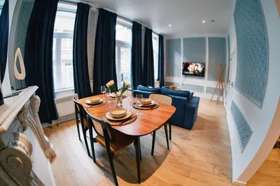 a dining room with a table and a couch at Urbanchic Adalbert 1A in Liège