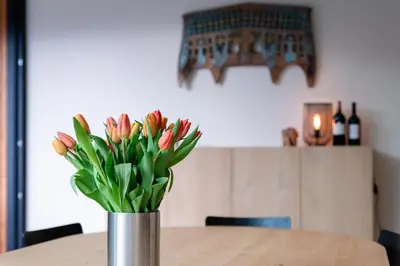 a vase of flowers sitting on top of a table at Vakantiehuis Remersdaal in Voeren