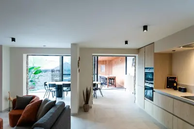 a kitchen and living room with a couch and a table at Vakantiehuis Remersdaal in Voeren