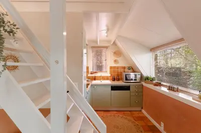a kitchen with a staircase leading up to a loft at Boshuisje Rekem - Olive in Lanaken