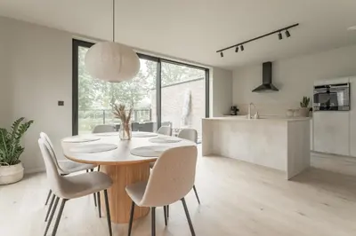 a kitchen and dining room with a table and chairs at Vakantie aan de Maas - Vakantiewoning Leenhof in Kinrooi