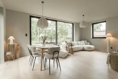 a living room with a table and chairs and a couch at Vakantie aan de Maas - Vakantiewoning Neerhof in Kinrooi