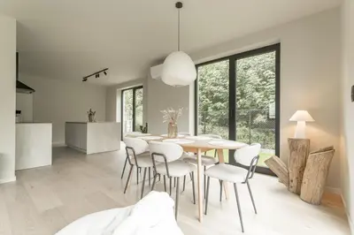 a kitchen and dining room with a table and chairs at Vakantie aan de Maas - Vakantiewoning Neerhof in Kinrooi