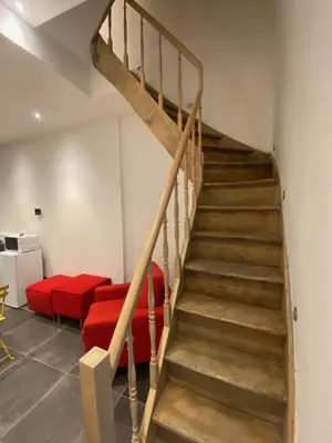 a staircase in a living room with a red couch at En NEUVICE 27 in Liège