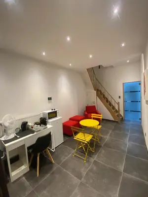 a living room with a red couch and yellow chairs at En NEUVICE 27 in Liège