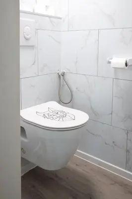 a bathroom with a toilet with graffiti on it at Corgi-Flowerhuisje in Lanaken