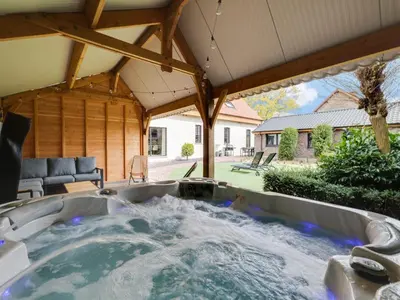 a large hot tub in a backyard with a patio at Vakantiehuis Bonne Home in Bree