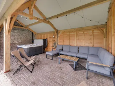a living room with a couch and a table and chairs at Vakantiehuis Bonne Home in Bree