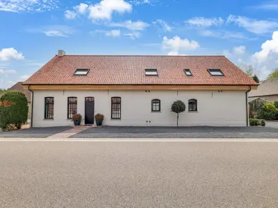 a white house with a red roof on a street at Vakantiehuis Bonne Home in Bree