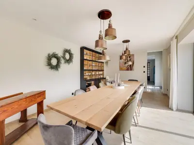 a dining room with a wooden table and chairs at Vakantiehuis Bonne Home in Bree