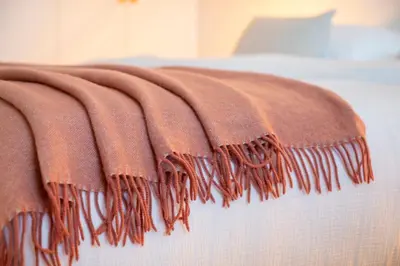 a brown blanket laying on top of a bed at Stee10 in Lanaken