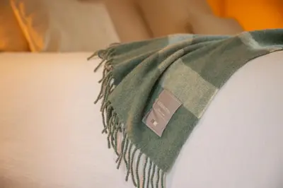 a green towel is hanging on the side of a bed at Stee10 in Lanaken