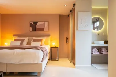 a bedroom with a large bed and a bathroom at Stee10 in Lanaken