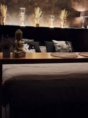 a table with a buddha statue sitting on top of it at Maison Beau in Zonhoven