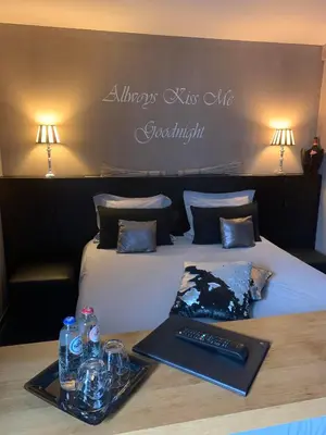 a hotel room with a bed with a keyboard and drinks at Maison Beau in Zonhoven