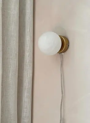 a lamp attached to a wall with a curtain at Residentie Papillon in Hasselt