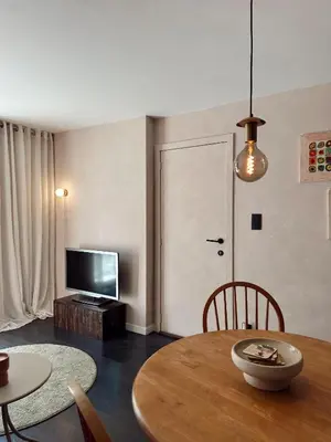 a living room with a table and a television at Residentie Papillon in Hasselt