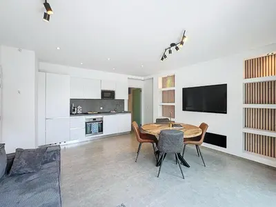 a living room with a table and chairs and a tv at Residence pascalino in Ans