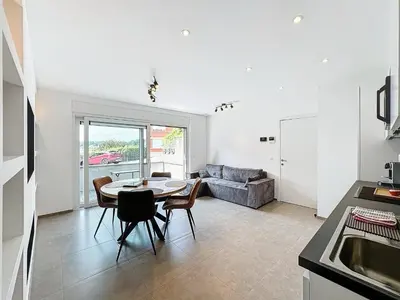 a kitchen and living room with a table and chairs at Residence pascalino in Ans