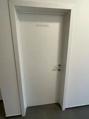 a white door with a sign on it at Residence pascalino in Ans