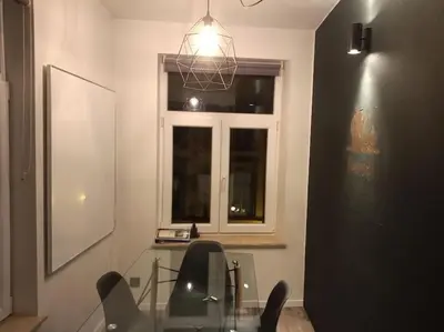 a dining room with a glass table and chairs and a window at La Vie Hors Château in Liège