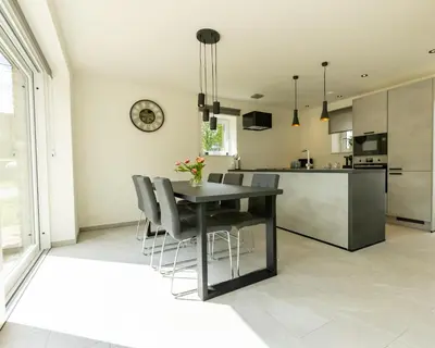 a kitchen and dining room with a table and chairs at Vakantiewoning De Ketten in Schoppem