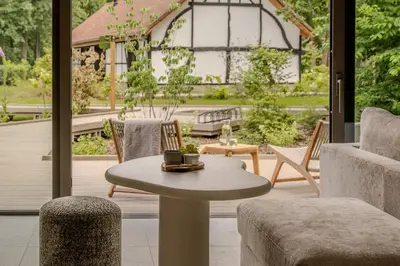a living room with a table and chairs and a patio at Suite - 2 personen - Woodz Lodges in Heusden - Zolder
