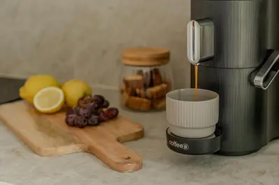a coffee maker sitting on a counter with fruit on a cutting board at Suite - 2 personen - Woodz Lodges in Heusden - Zolder