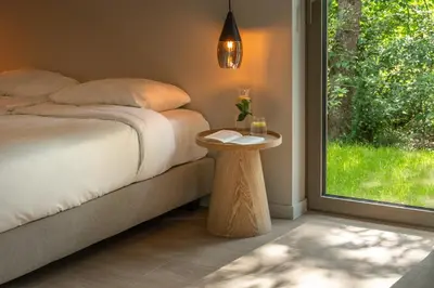 a bedroom with a bed with a table and a window at Suite - 2 personen - Woodz Lodges in Heusden - Zolder