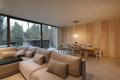 a living room with a couch and a table with chairs at Lodge met Jacuzzi - 8 personen - Woodz Lodges in Heusden - Zolder