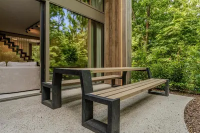 a wooden bench sitting outside of a house at Lodge met Jacuzzi - 8 personen - Woodz Lodges in Heusden - Zolder