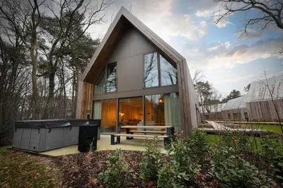 a small house with a tub in the yard at Lodge met Jacuzzi - 8 personen - Woodz Lodges in Heusden - Zolder
