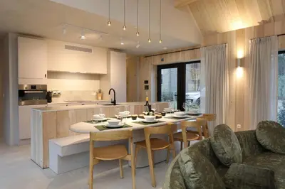 a kitchen and living room with a table and chairs at Villa Lodge met Jacuzzi - 8 personen - Woodz Lodges in Heusden - Zolder