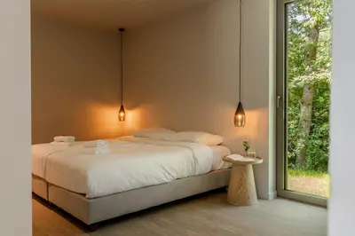 a bedroom with a large bed and a window at Suite Toegankelijk | 2 personen in Heusden - Zolder