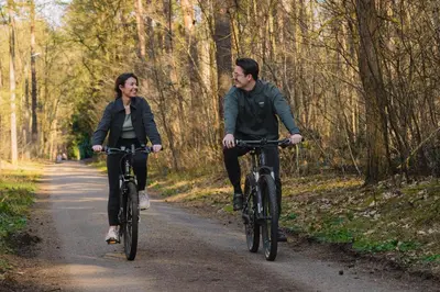 a man and woman riding bikes down a trail at Suite Toegankelijk | 2 personen in Heusden - Zolder