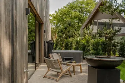 a patio with two chairs and a water fountain at Wellness Suite - 2 personen - Woodz Lodges in Heusden - Zolder