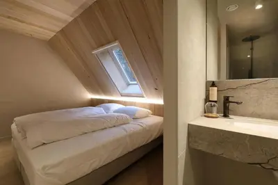 a bedroom with a bed with a window and a sink at Lodge - 8 personen - Woodz Lodges in Heusden - Zolder