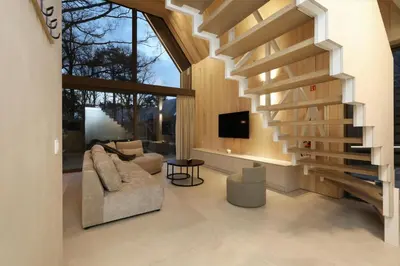 a living room with a staircase and a couch at Lodge - 6 personen - Woodz Lodges in Heusden - Zolder