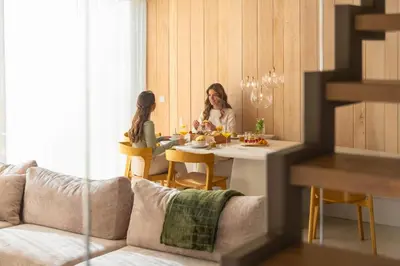 two women sitting at a table in a living room at Groepslodge - 10 personen - Woodz Lodges in Heusden - Zolder
