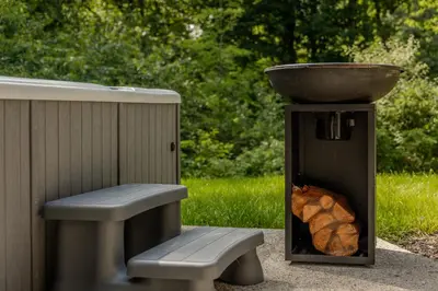 a grill with a bowl on top and a bench at Lodge met Jacuzzi - 6 personen - Woodz Lodges in Heusden - Zolder