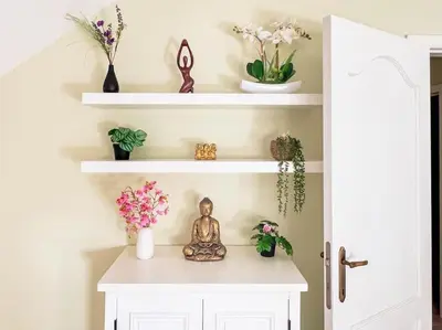 a shelf with a buddha statue and flowers on it at Modern Loft with 2 bedrooms near Sint Truiden in Herk-de-Stad