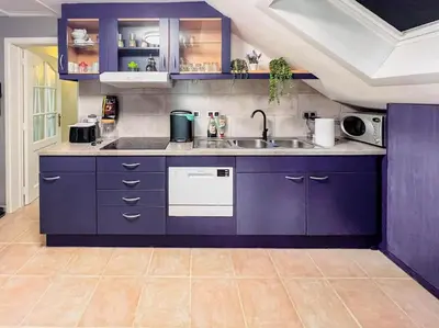 a kitchen with purple cabinets and a sink at Modern Loft with 2 bedrooms near Sint Truiden in Herk-de-Stad